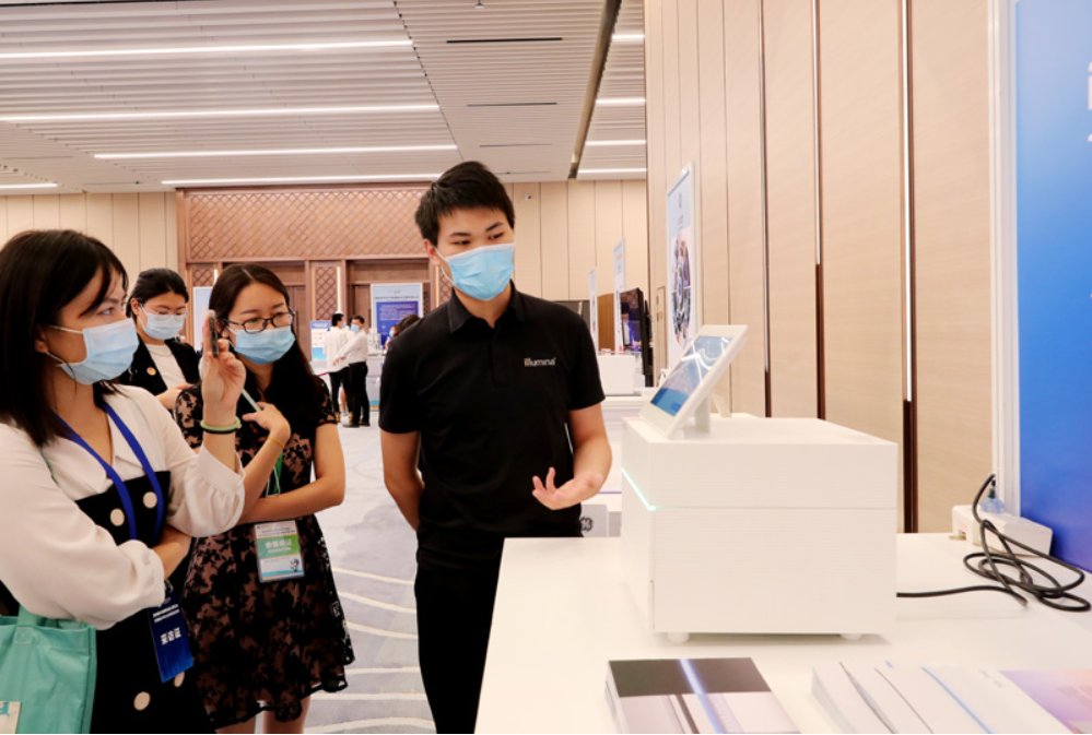 第四屆進(jìn)博會(huì)食品及農(nóng)產(chǎn)品展區(qū)、醫(yī)療器械及醫(yī)藥保健展區(qū)展前供需對(duì)接會(huì)的工作人員在介紹一臺(tái)測序儀展品